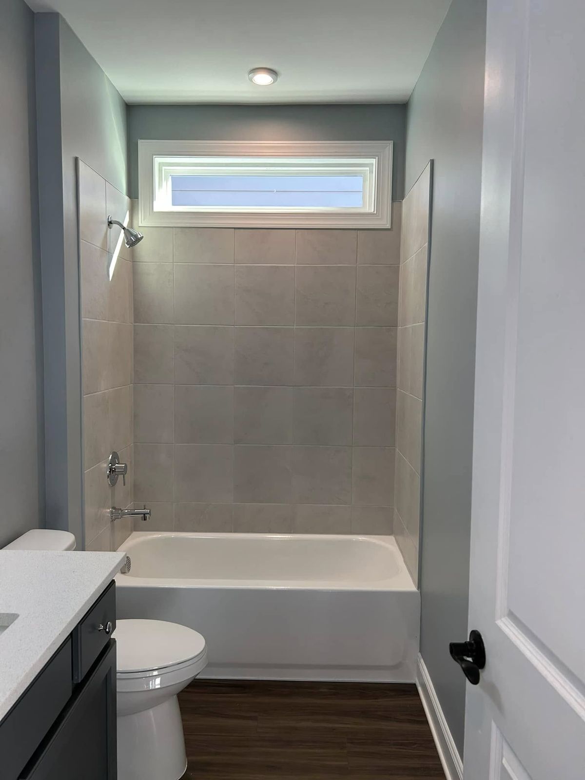 Bathroom with gray painted walls and white trim around the tub