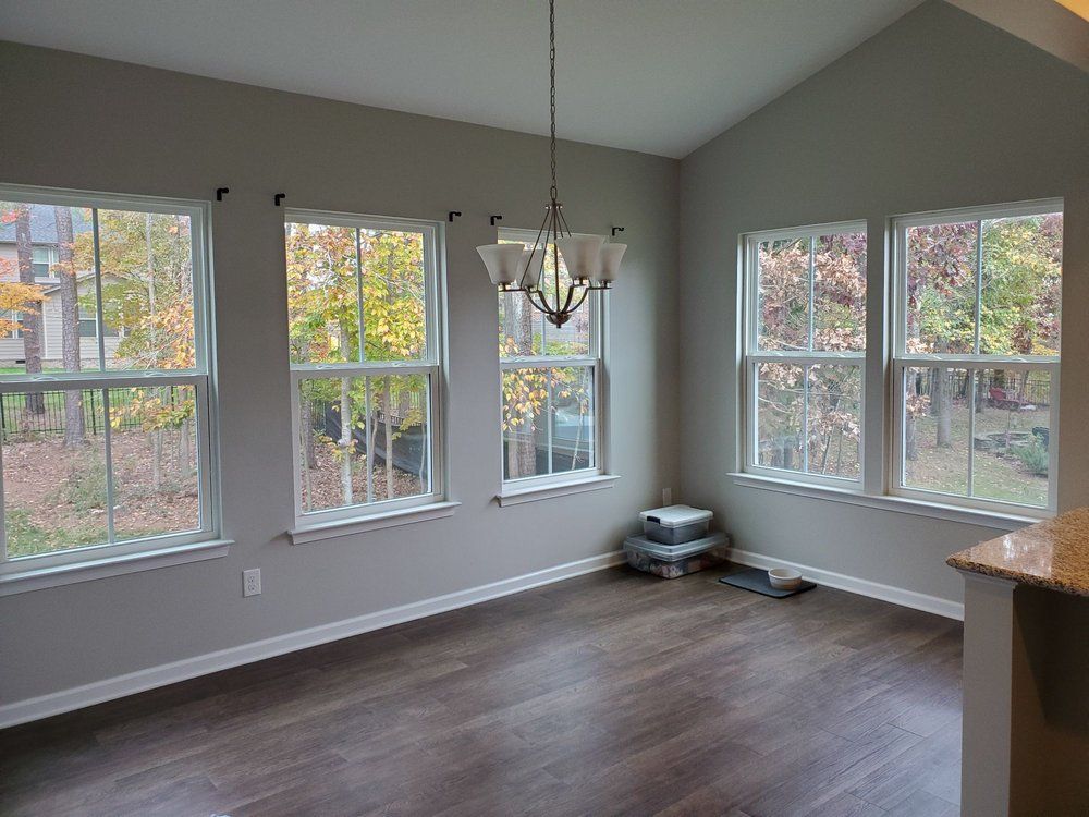 Breakfast room with freshly painted gray walls, white trim and a wall of windows