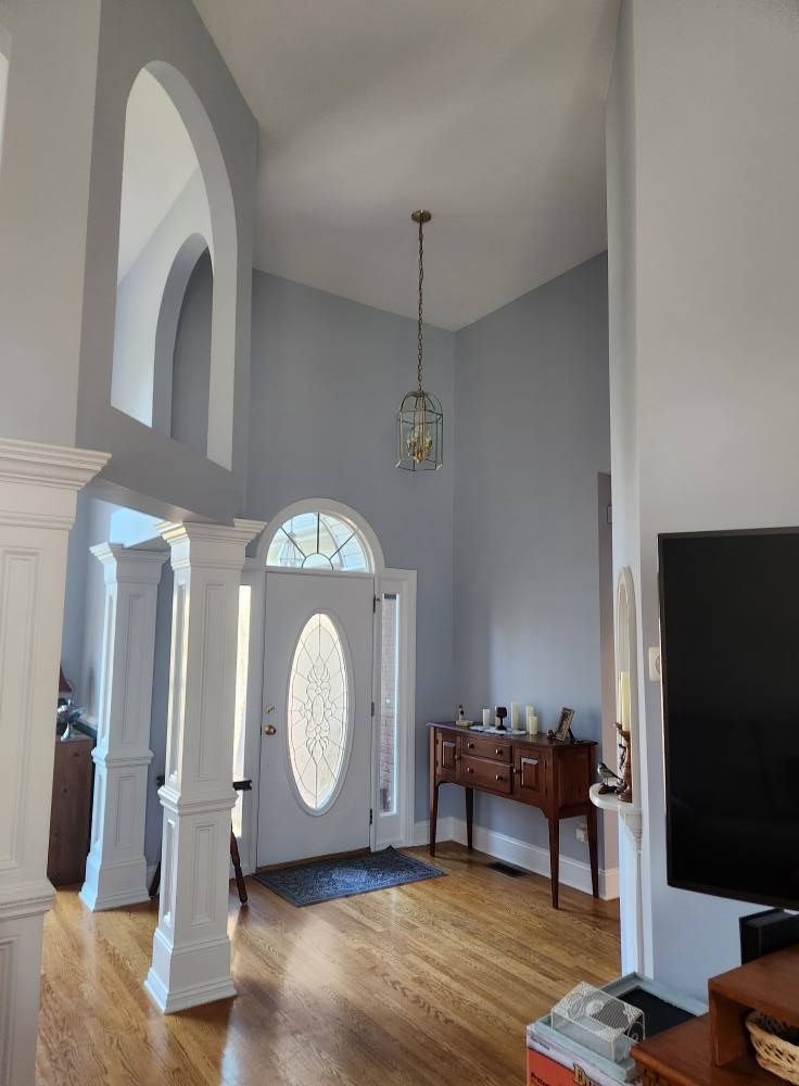 Two-story foyer painted white around an arched front door