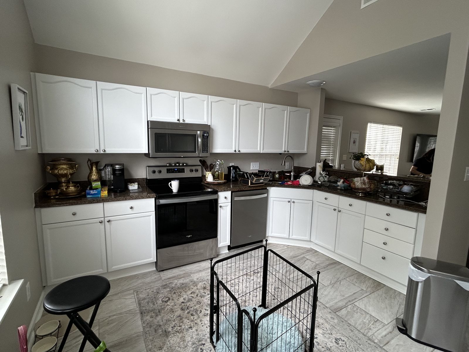 Bright kitchen with white painted cabinets and dark countertops