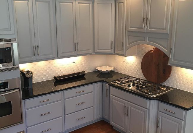 Kitchen with white painted cabinets and under-cabinet lighting