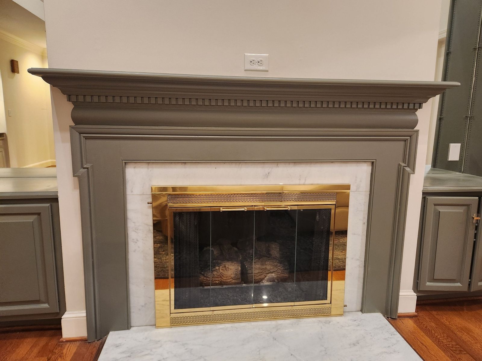 Fireplace mantel painted in a warm taupe with a marble surround