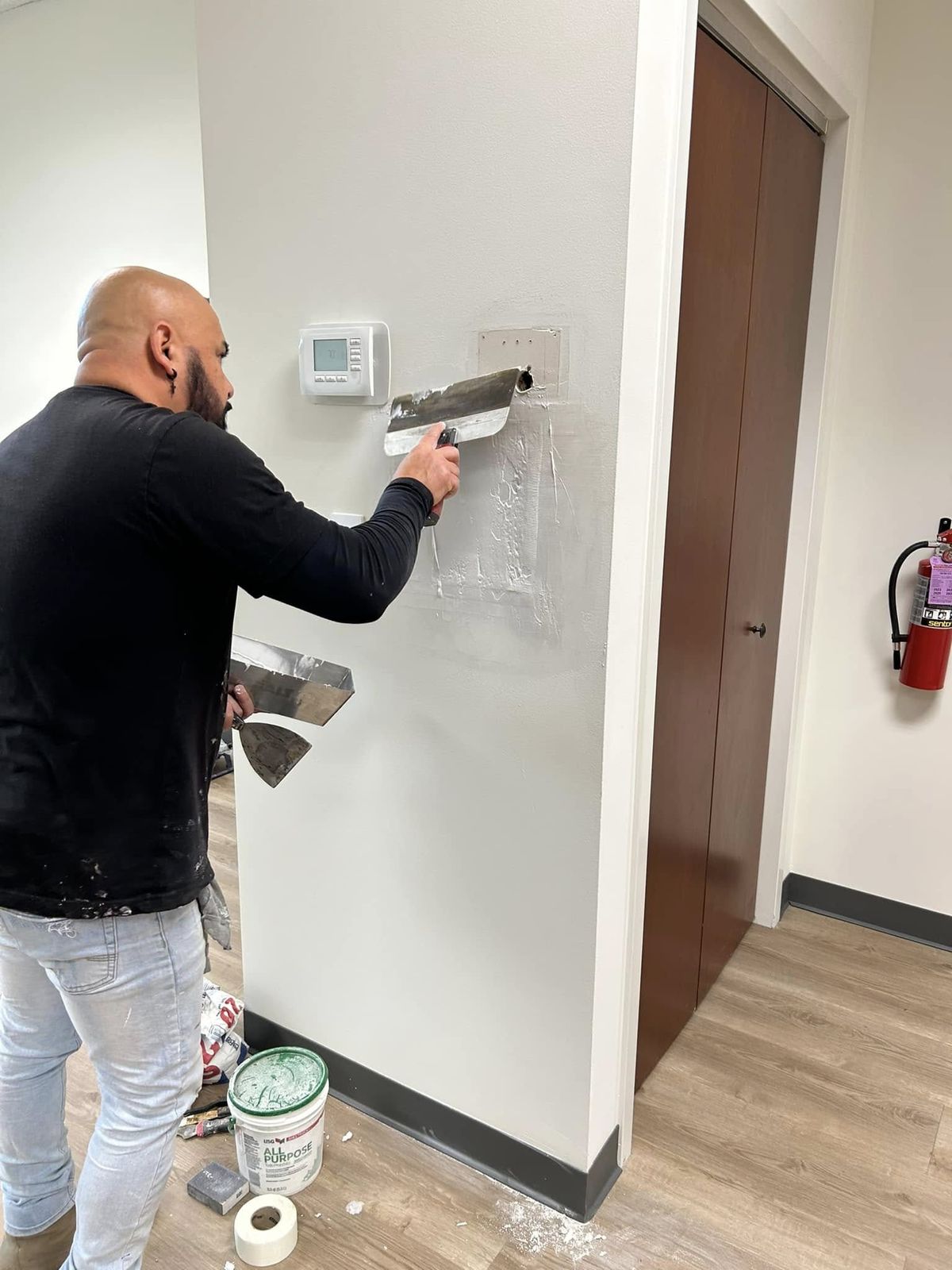 Painter cutting in a wall corner inside an office