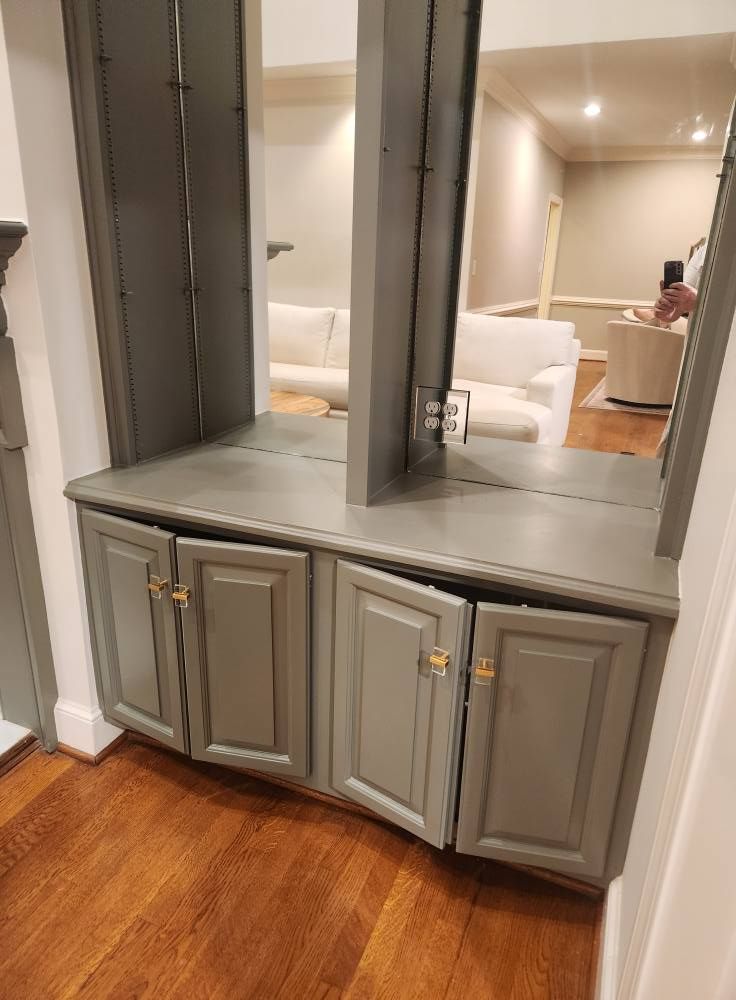 Bathroom vanity cabinets painted gray with a double mirror